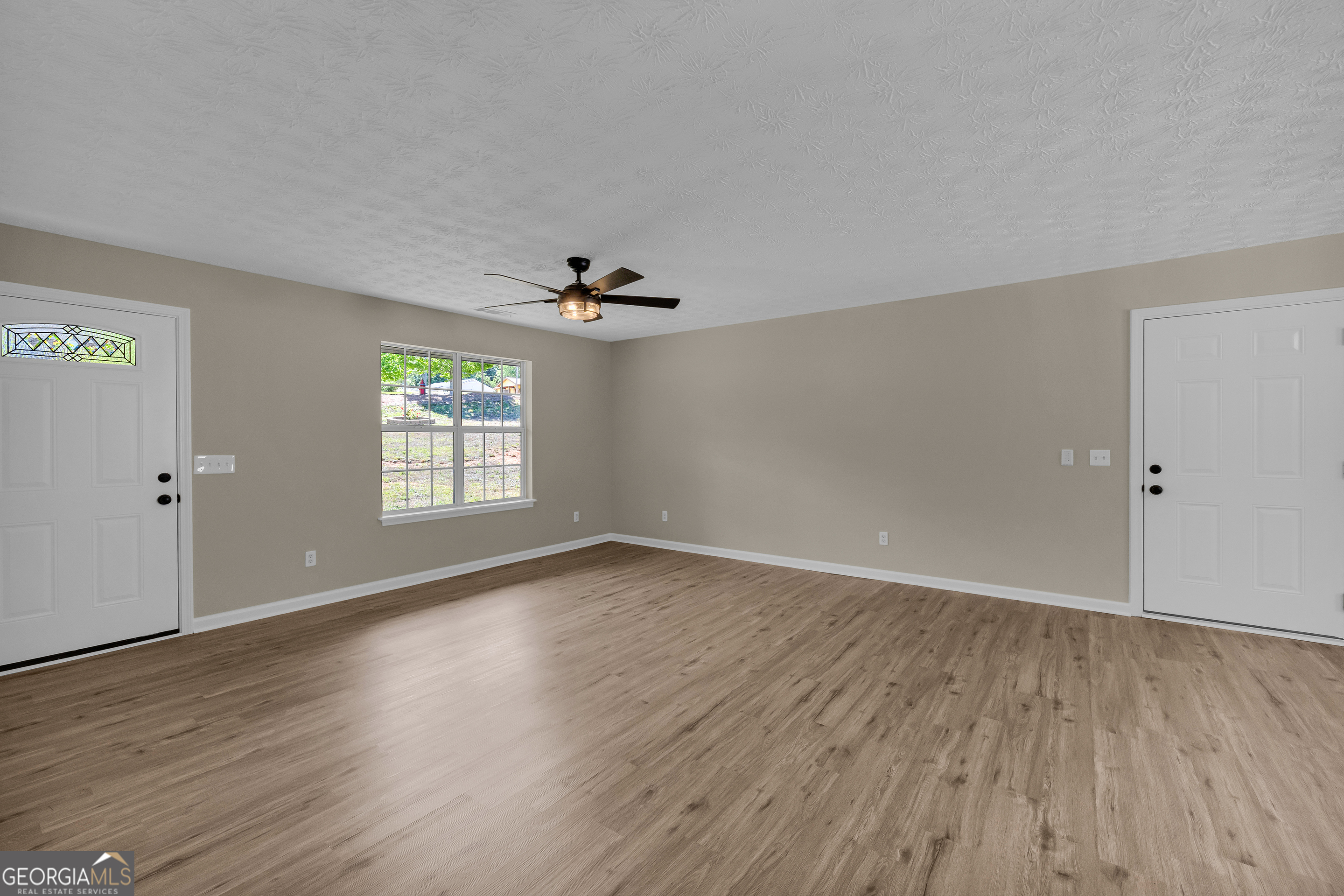 248 Highland Estates Commerce, GA 30529 - Photo 19 of 57 an empty room with wooden floor chandelier fan and windows