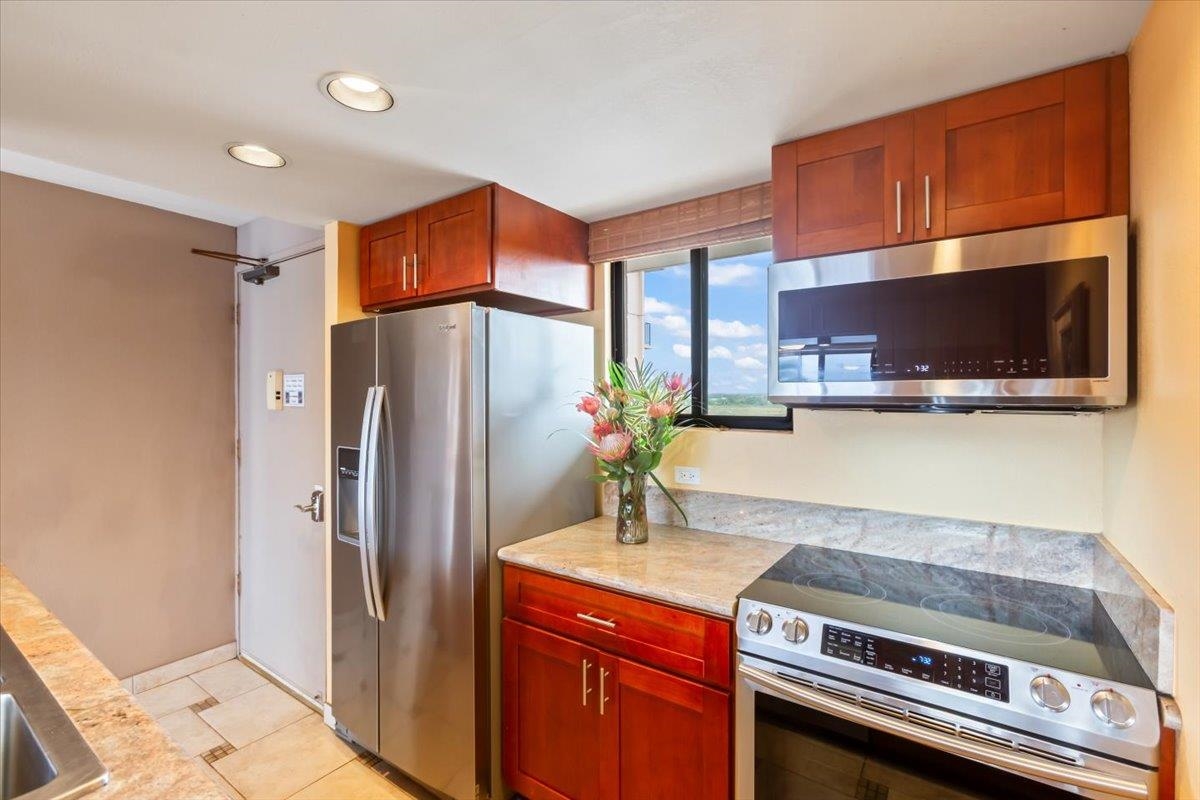 191 North Kihei Road, Unit 402 Kihei, HI 96753 - Photo 16 of 48 a kitchen with stainless steel appliances granite countertop a refrigerator and a stove