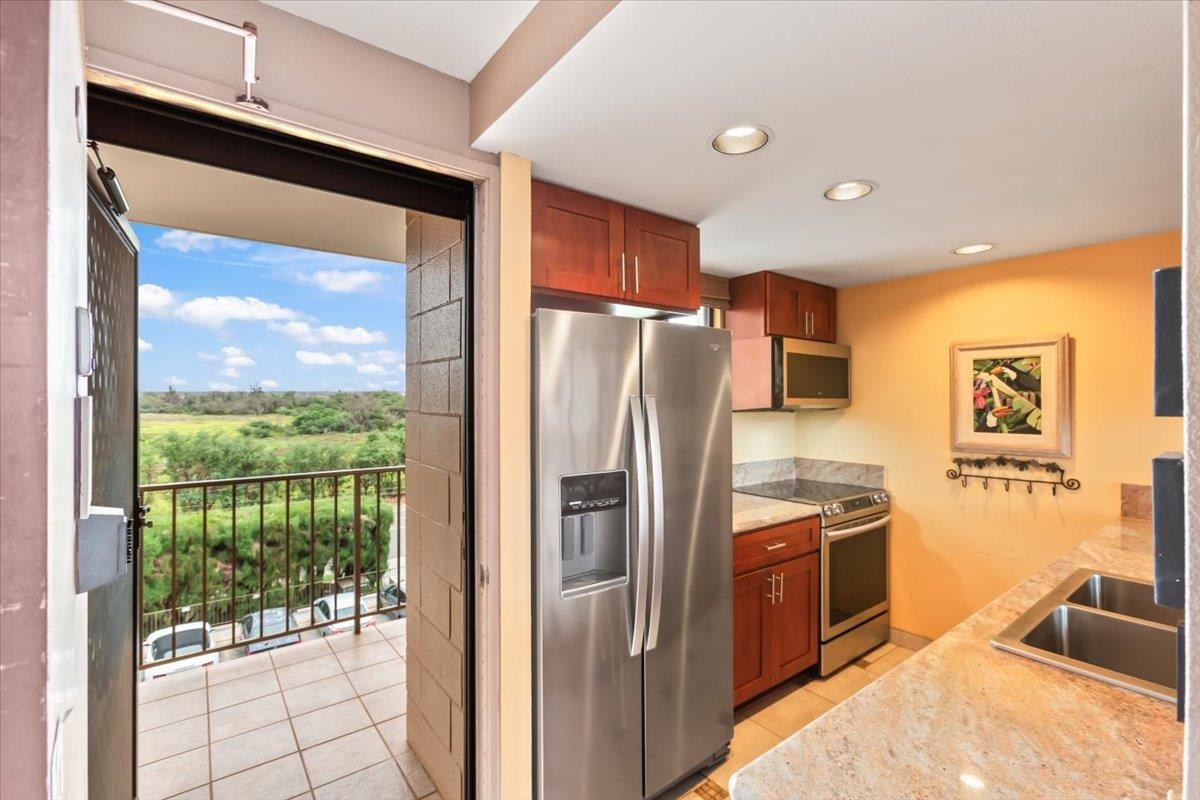 191 North Kihei Road, Unit 402 Kihei, HI 96753 - Photo 28 of 48 a kitchen with stainless steel appliances granite countertop a refrigerator and a sink