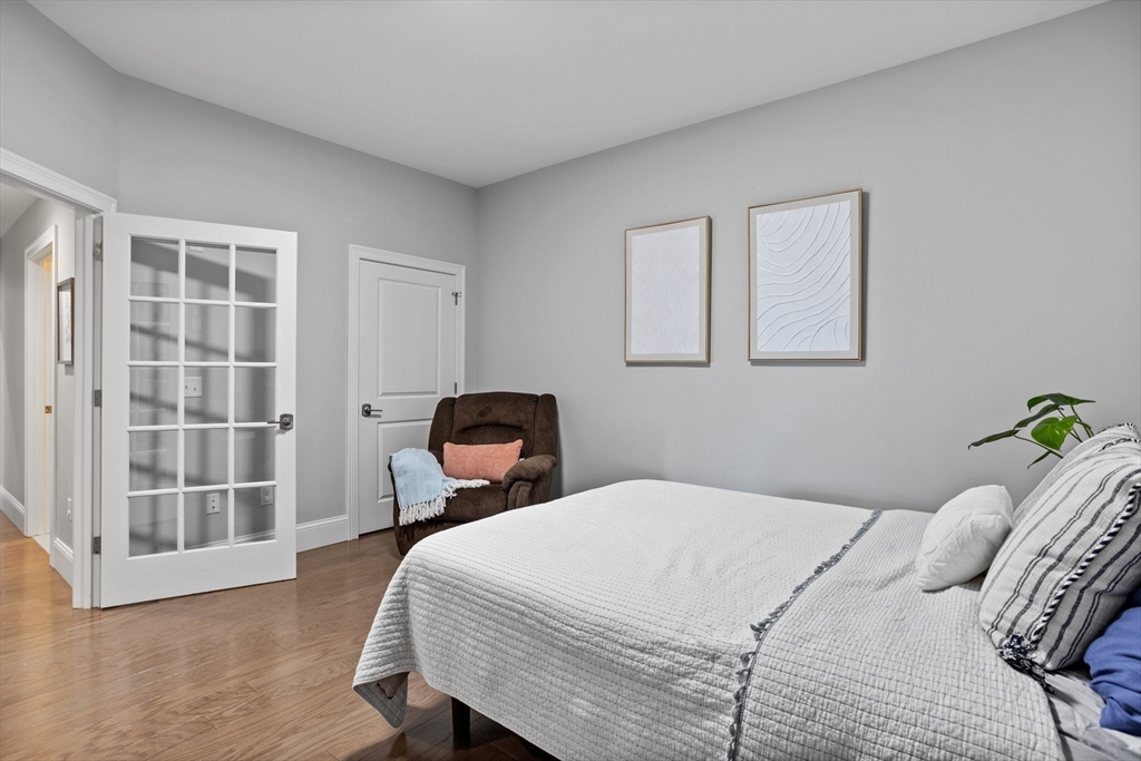 8 Sanborn Street, Unit 2012 Reading, MA 01867 - Photo 21 of 36 a bedroom with a bed and wooden floor