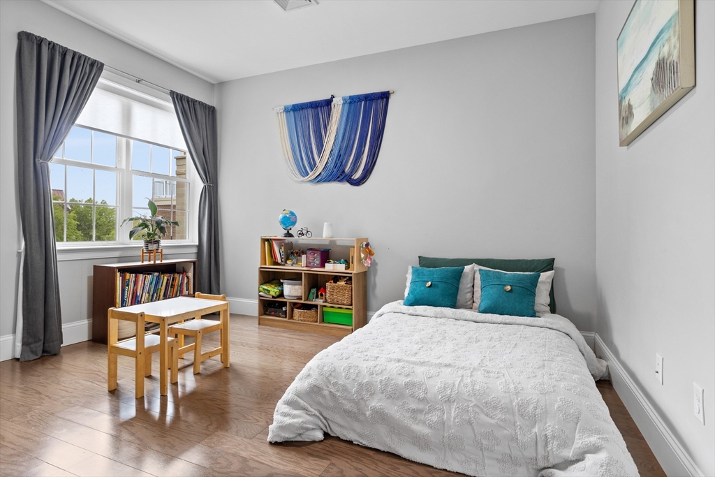 8 Sanborn Street, Unit 2012 Reading, MA 01867 - Photo 23 of 36 a bedroom with a bed a table and chair