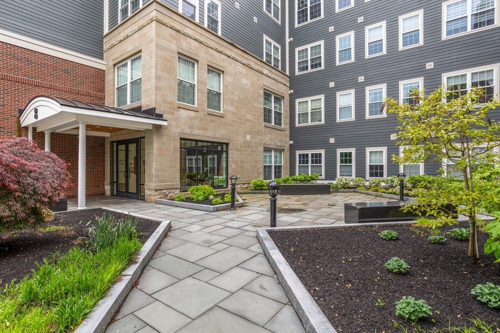 8 Sanborn Street, Unit 2012 Reading, MA 01867 - Photo 35 of 36 a front view of a house with a yard and potted plants