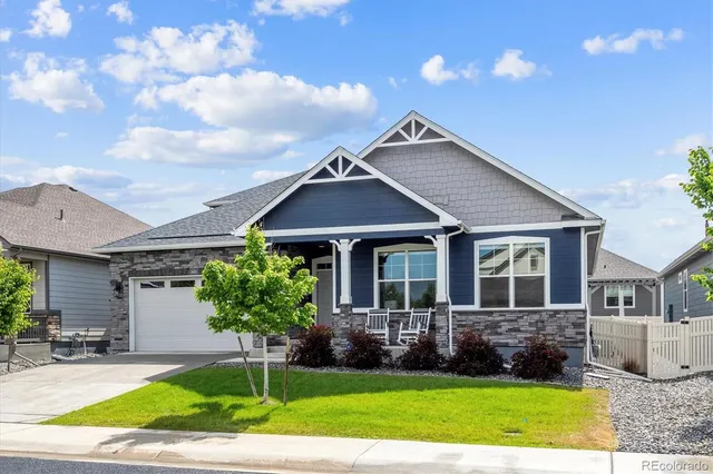 a front view of a house with a yard and potted plants