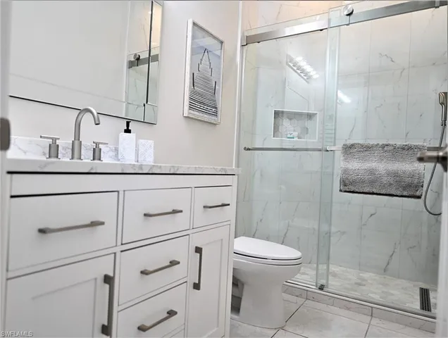 a bathroom with a shower sink vanity and toilet