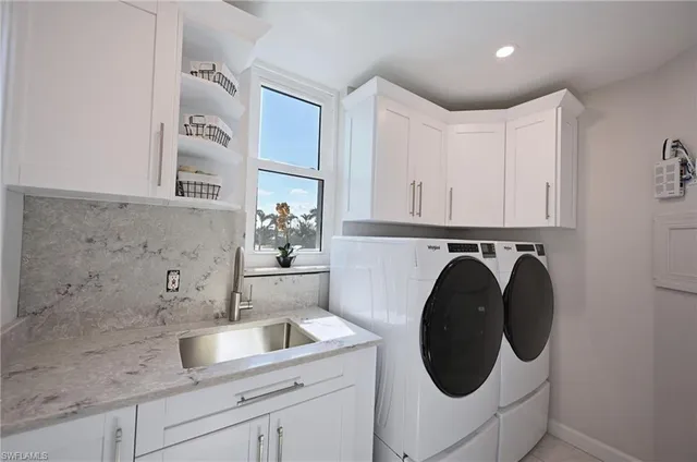 a utility room with sink dryer and washer