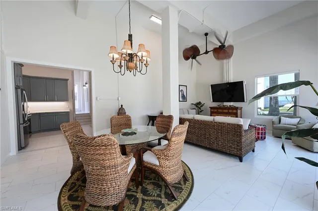 a living room with furniture a flat screen tv and kitchen view