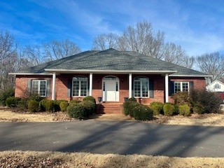 a front view of house with yard and trees around