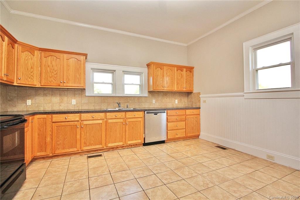 694 Main Street Southwest Concord, NC 28027 - Photo 14 of 33 a kitchen with granite countertop a stove a sink and a granite counter tops
