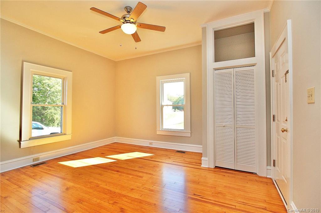 694 Main Street Southwest Concord, NC 28027 - Photo 4 of 33 a view of an empty room with a window and wooden floor