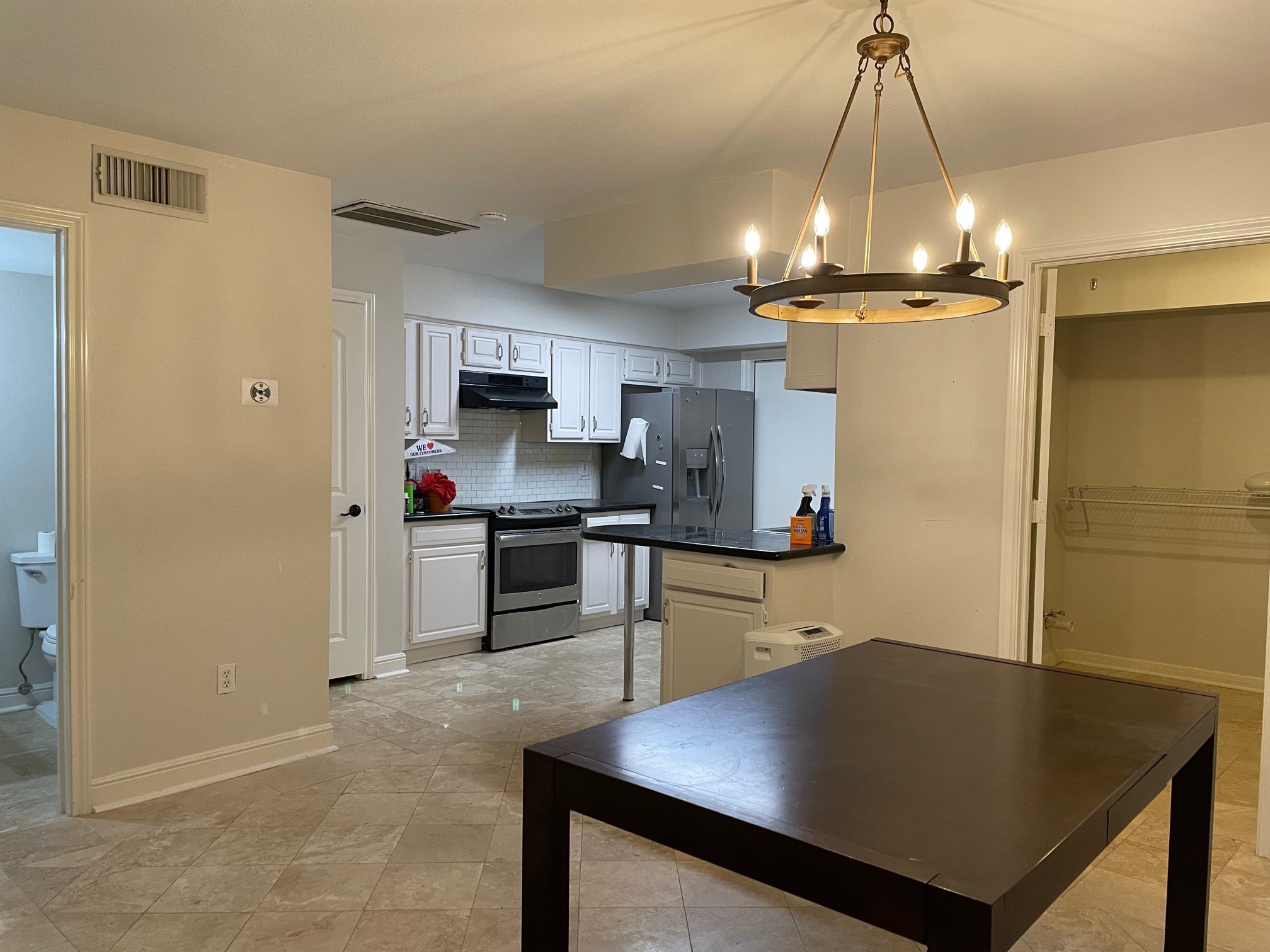 4502 Dickson Street Houston, TX 77007 - Photo 4 of 8 a kitchen with stainless steel appliances a dining table chairs and a refrigerator