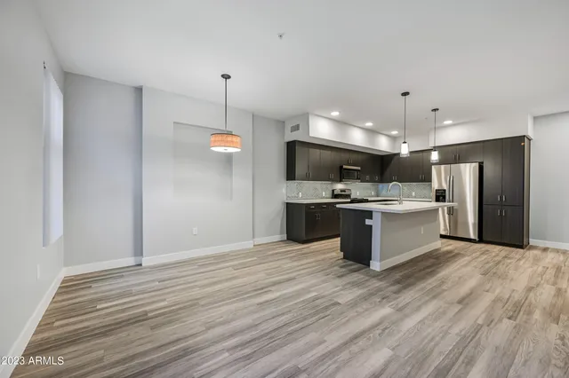 a large kitchen with a refrigerator and a microwave