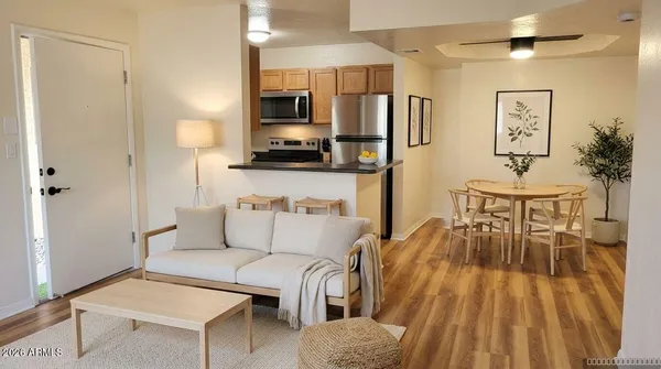 a living room with furniture a flat screen tv and kitchen view