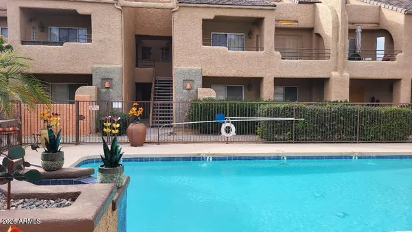 a view of swimming pool with lawn chairs and a fire pit