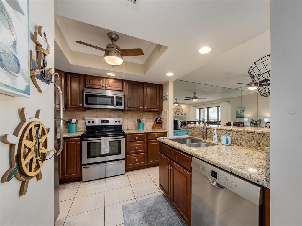 2406 Gulf Boulevard, Unit 204 Indian Rocks Beach, FL 33785 - Photo 15 of 39 a kitchen with stainless steel appliances granite countertop a stove and a sink