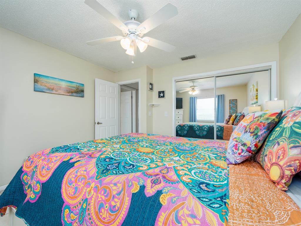 2406 Gulf Boulevard, Unit 204 Indian Rocks Beach, FL 33785 - Photo 22 of 39 a bedroom with a bed and a chandelier