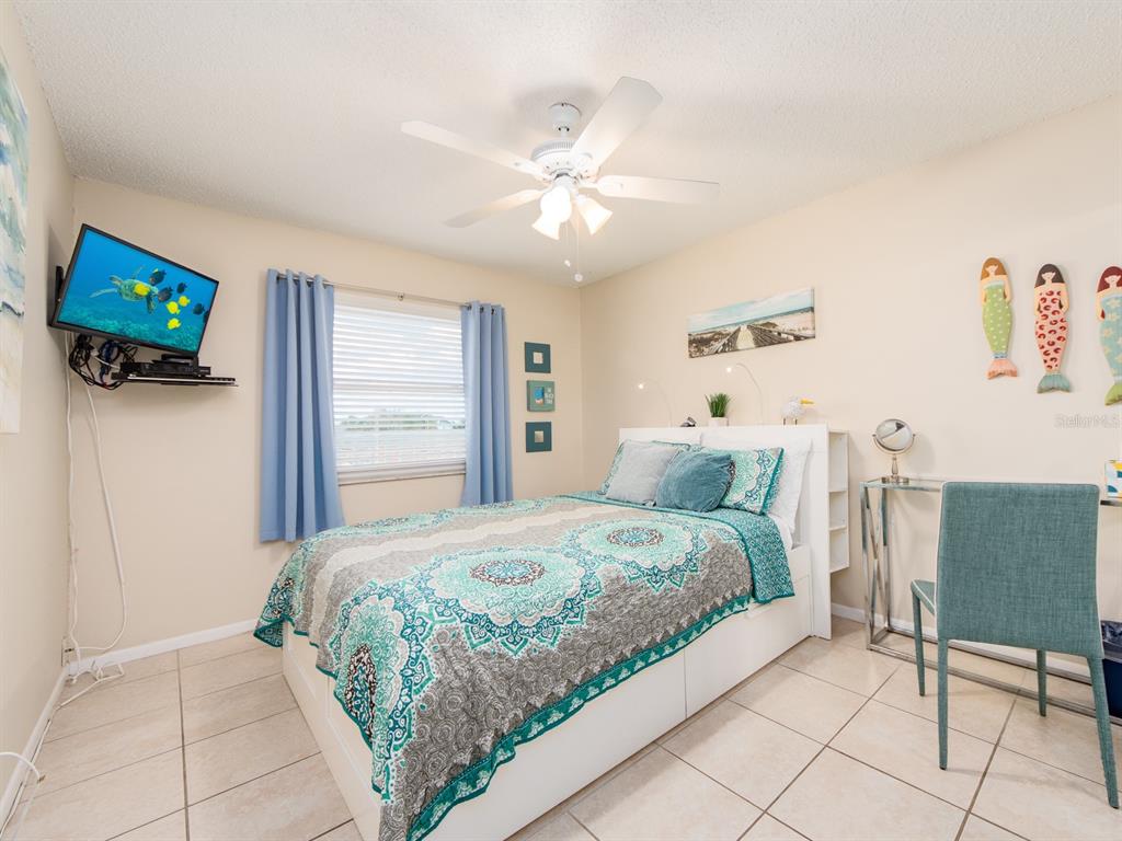 2406 Gulf Boulevard, Unit 204 Indian Rocks Beach, FL 33785 - Photo 26 of 39 a bedroom with a bed and a television