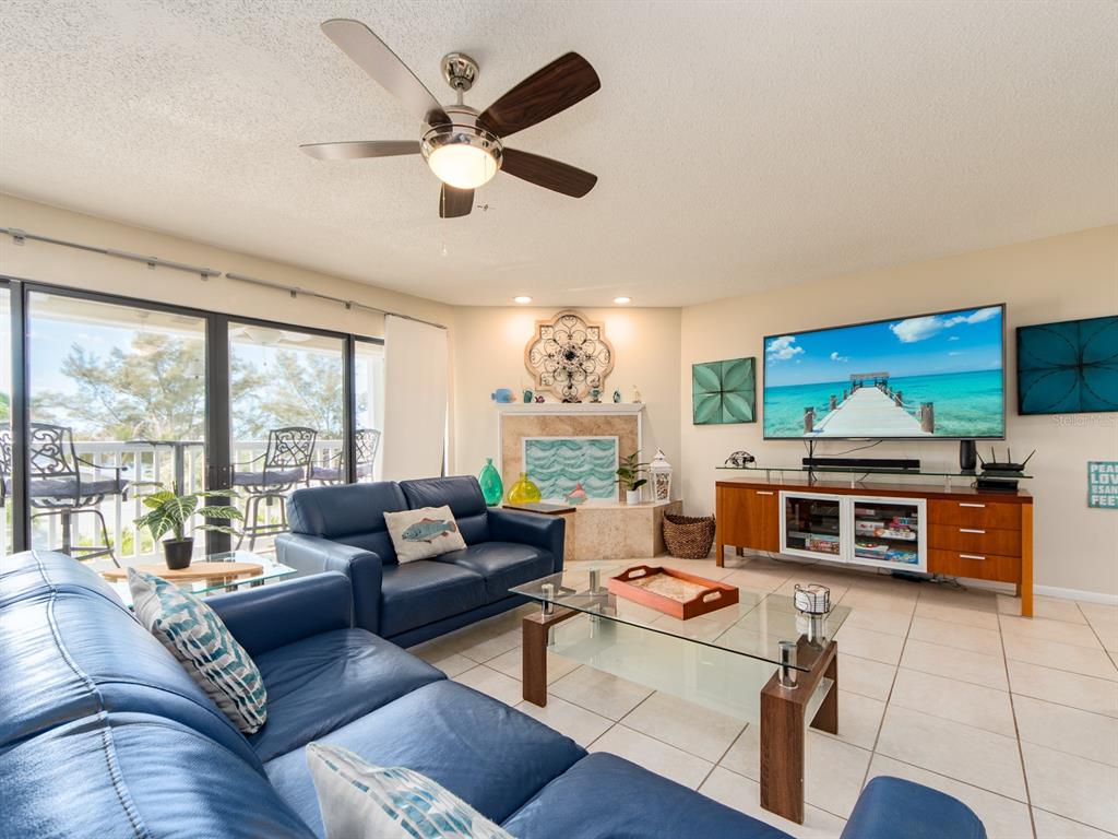 2406 Gulf Boulevard, Unit 204 Indian Rocks Beach, FL 33785 - Photo 7 of 39 a living room with furniture a flat screen tv and a large window