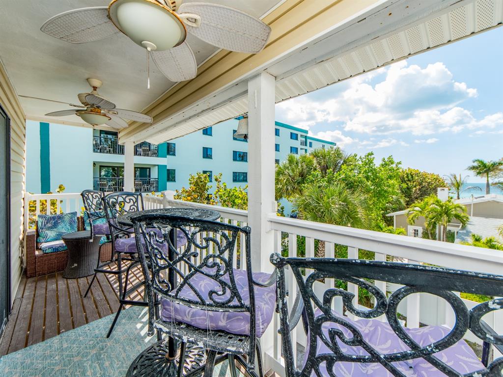 2406 Gulf Boulevard, Unit 204 Indian Rocks Beach, FL 33785 - Photo 9 of 39 a roof deck with dining table and chairs with wooden floor