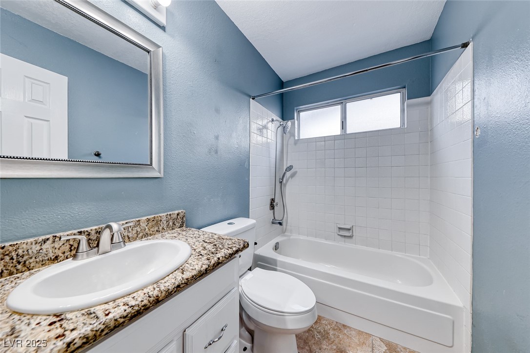 632 Arrayo Way Boulder City, NV 89005 - Photo 34 of 40 Bathroom with toilet, tub / shower combination, vanity, and a textured wall