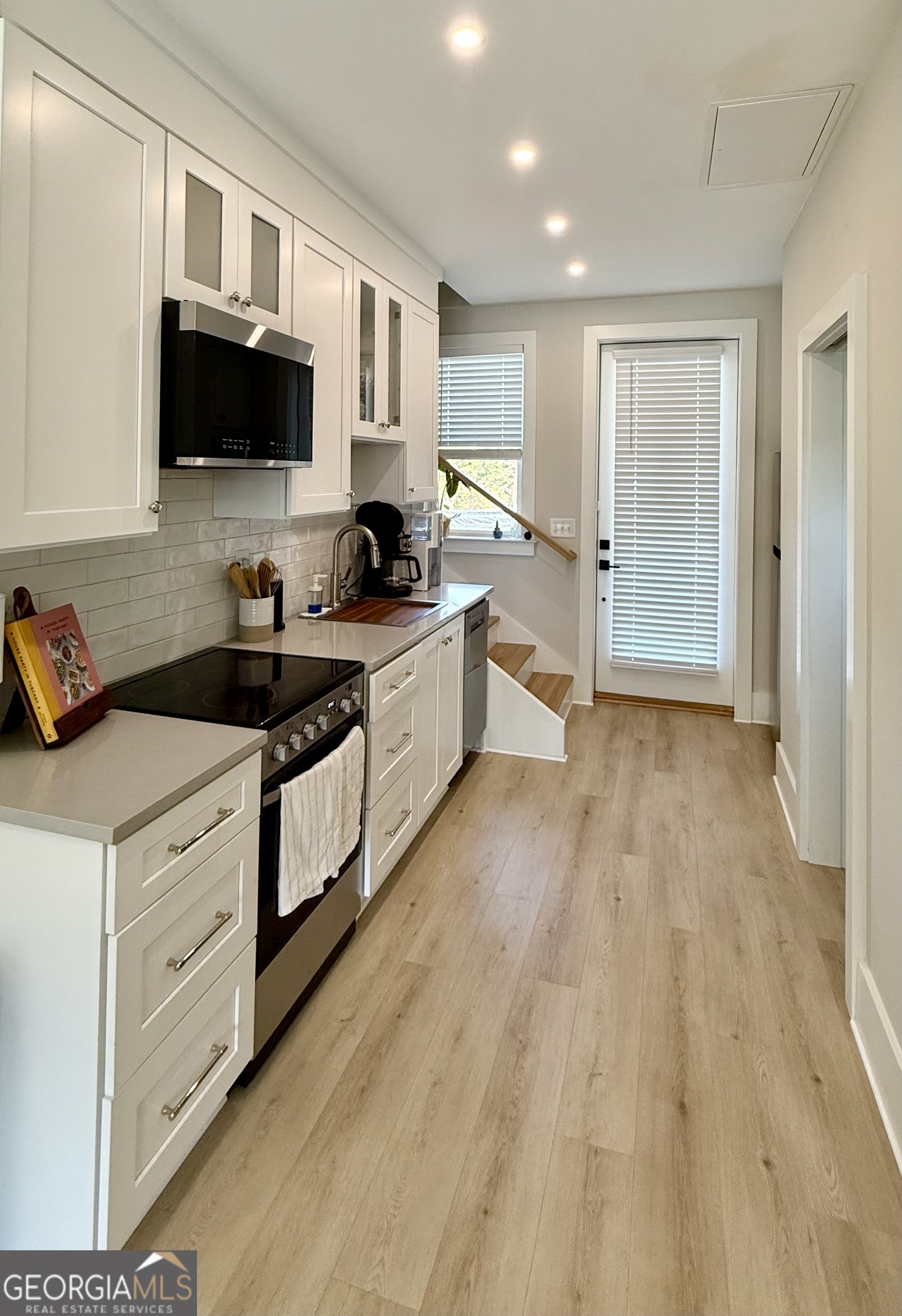1 East Jarrard Street Cleveland, GA 30528 - Photo 7 of 23 a kitchen with granite countertop a sink cabinets and wooden floor
