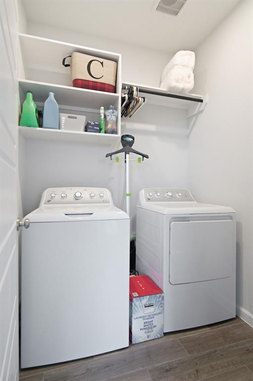 201 Pintail Lane Rhome, TX 76078 - Photo 27 of 36 Dedicated laundry space featuring white cabinetry and shelving, a clothing rod, and wood-finish flooring
