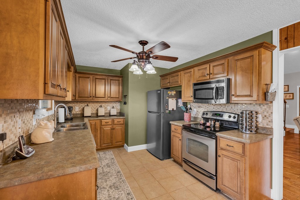 465 Hickory Lane Sparta, TN 38583 - Photo 27 of 46 a kitchen with stainless steel appliances granite countertop a stove a sink dishwasher a refrigerator and a microwave oven with cabinets