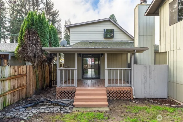 a view of a house with a yard and wooden fence