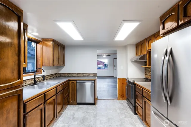 a kitchen with stainless steel appliances granite countertop a sink and a refrigerator