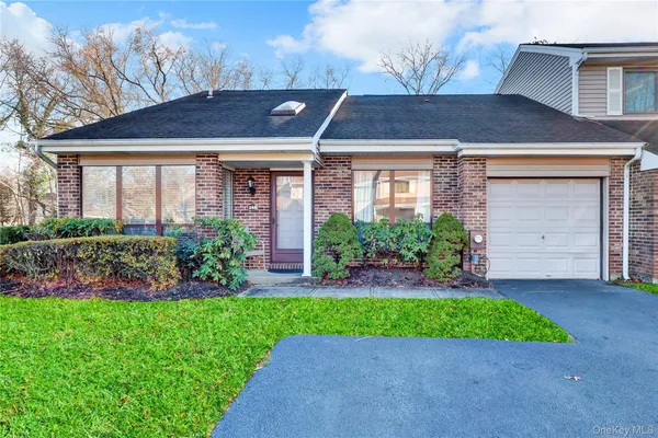 a front view of a house with a garden and plants