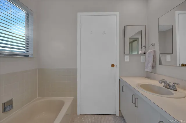 a bathroom with a sink a bathtub and a window