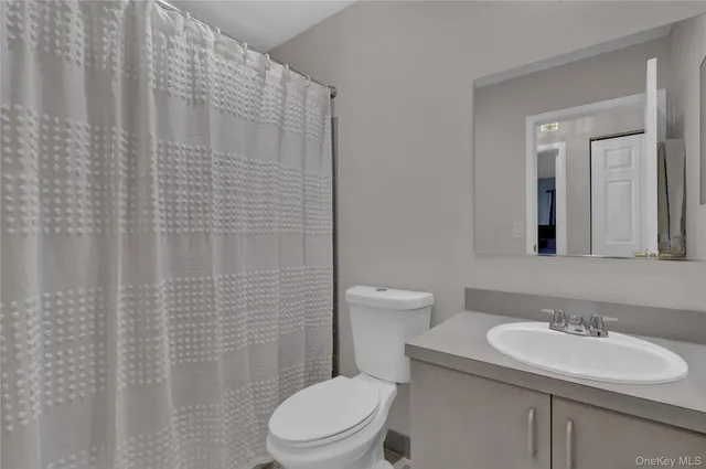 a bathroom with a toilet a sink and mirror