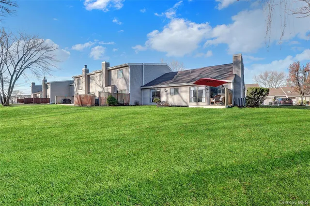 a view of a house with a big yard and large trees