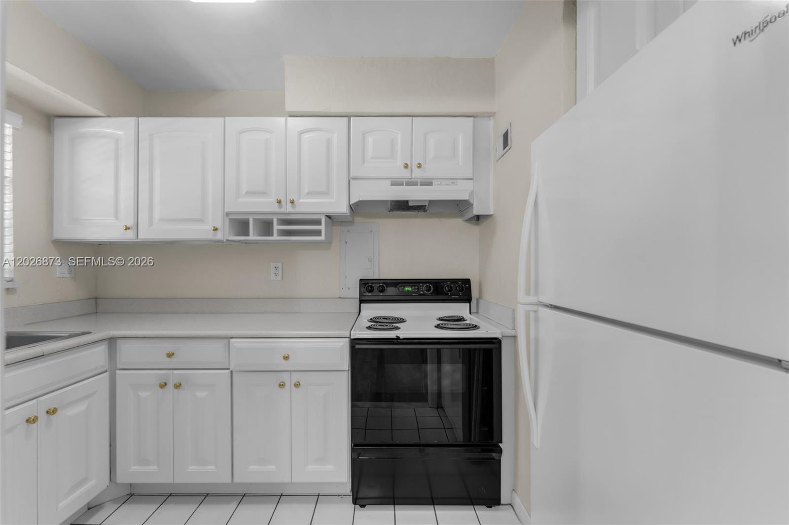 5590 Southwest 78th Street, Unit 133B Miami, FL 33143 - Photo 5 of 18 a kitchen with white cabinets and white appliances