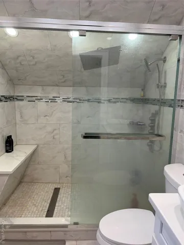 a white toilet sitting next to a shower
