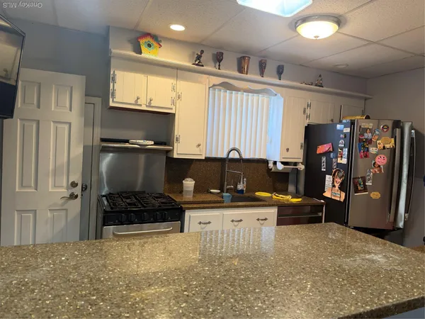 a kitchen with stainless steel appliances a stove a refrigerator and a refrigerator