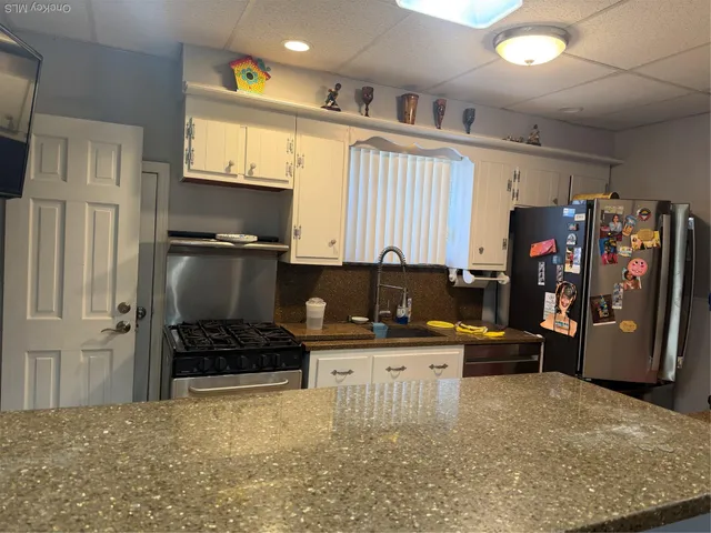 a kitchen with stainless steel appliances a stove a refrigerator and a refrigerator