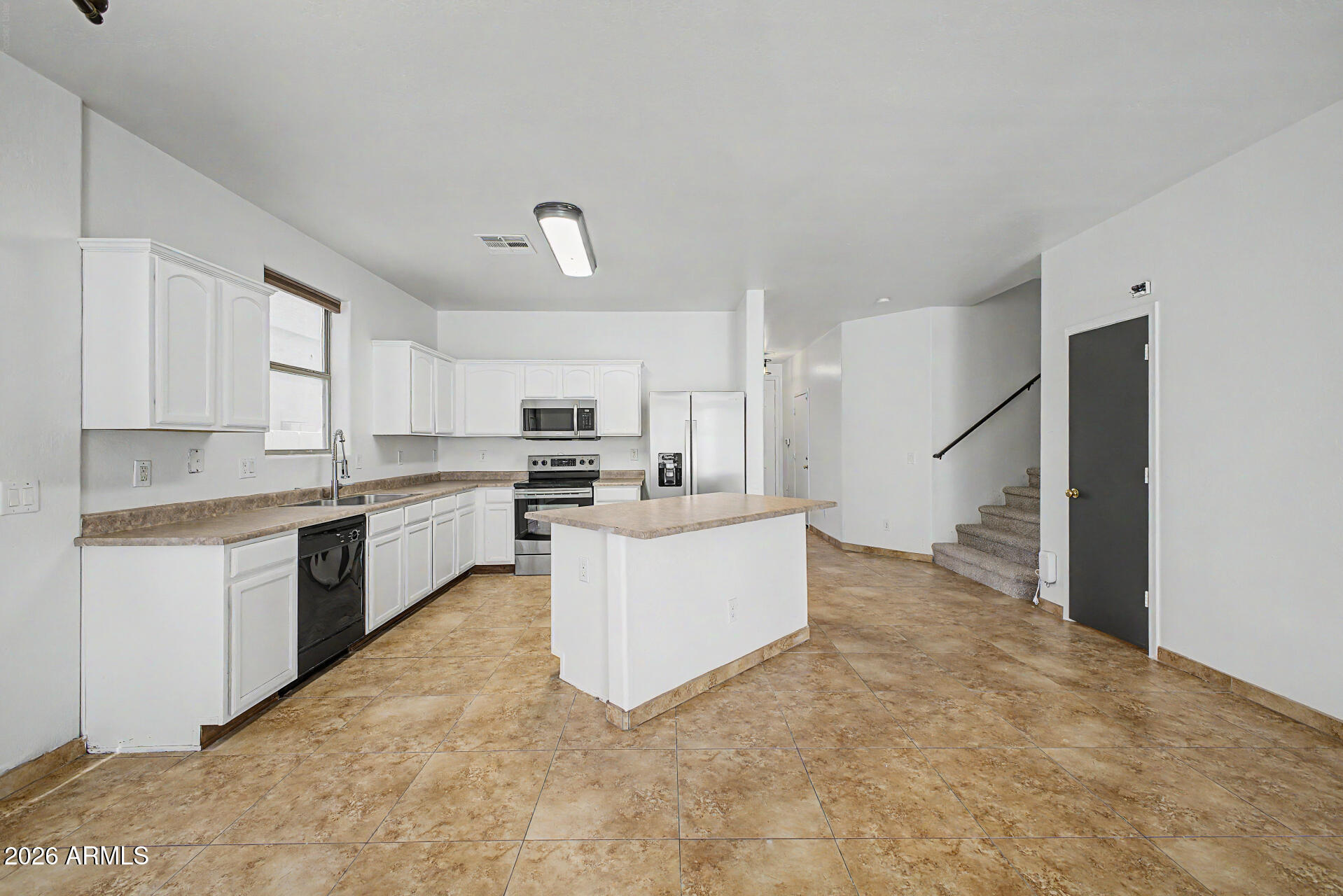 45571 West Tucker Road Maricopa, AZ 85139 - Photo 16 of 61 a large kitchen with kitchen island a sink a stove and refrigerator