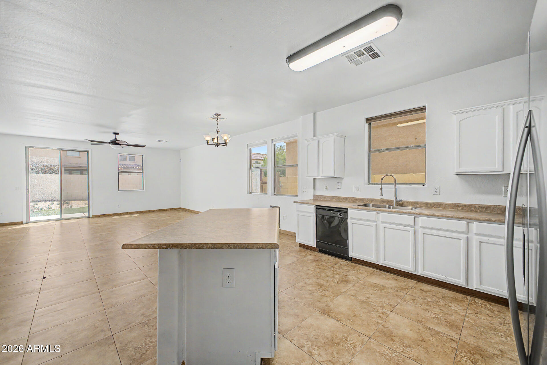 45571 West Tucker Road Maricopa, AZ 85139 - Photo 18 of 61 a kitchen with granite countertop a sink and white cabinets
