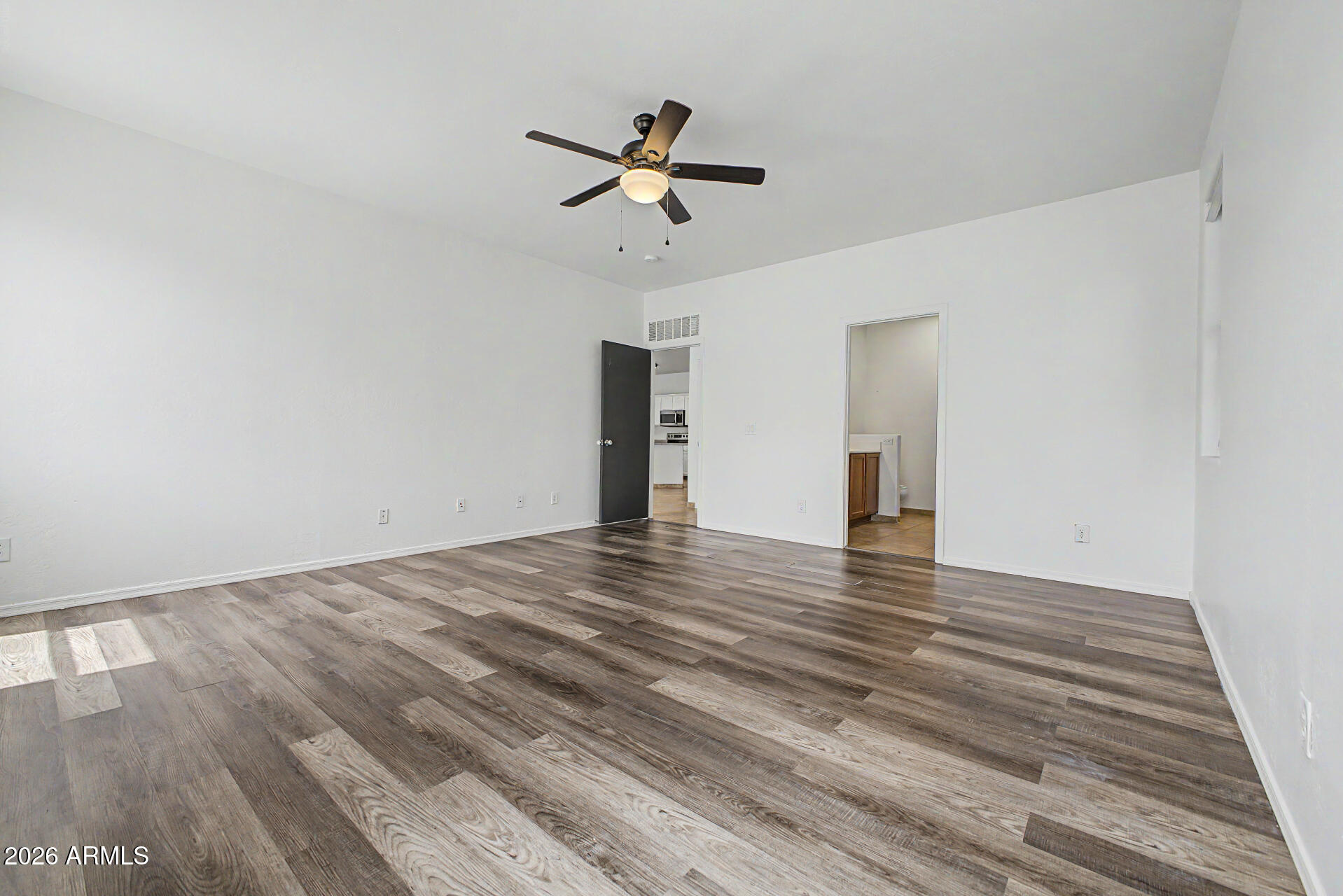 45571 West Tucker Road Maricopa, AZ 85139 - Photo 24 of 61 a view of empty room with wooden floor and ceiling fan