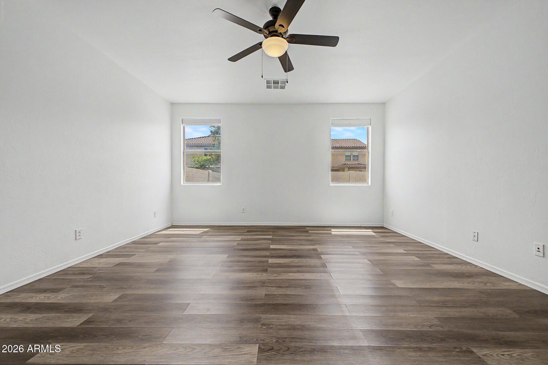 45571 West Tucker Road Maricopa, AZ 85139 - Photo 25 of 61 an empty room with wooden floor chandelier fan and windows