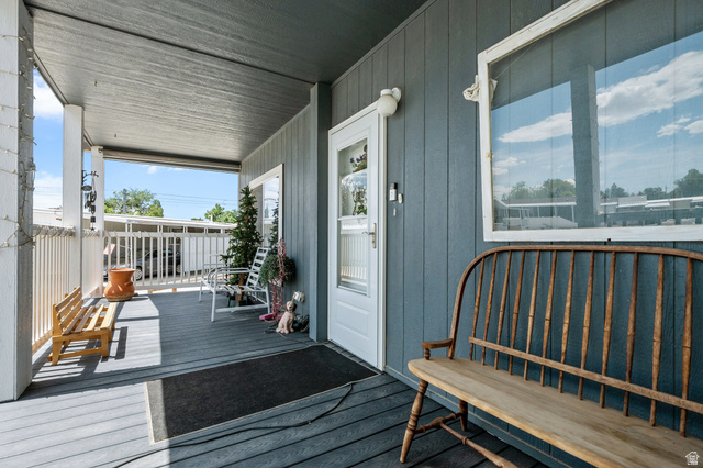 150 West 7500th South, Unit 13 Midvale, UT 84047 - Photo 25 of 32 Covered porch featuring gray wood-finish decking, white railings, and a light blue exterior wall