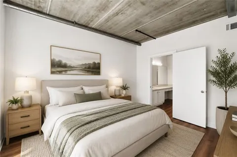 a bedroom with a bed and a painting on the wall