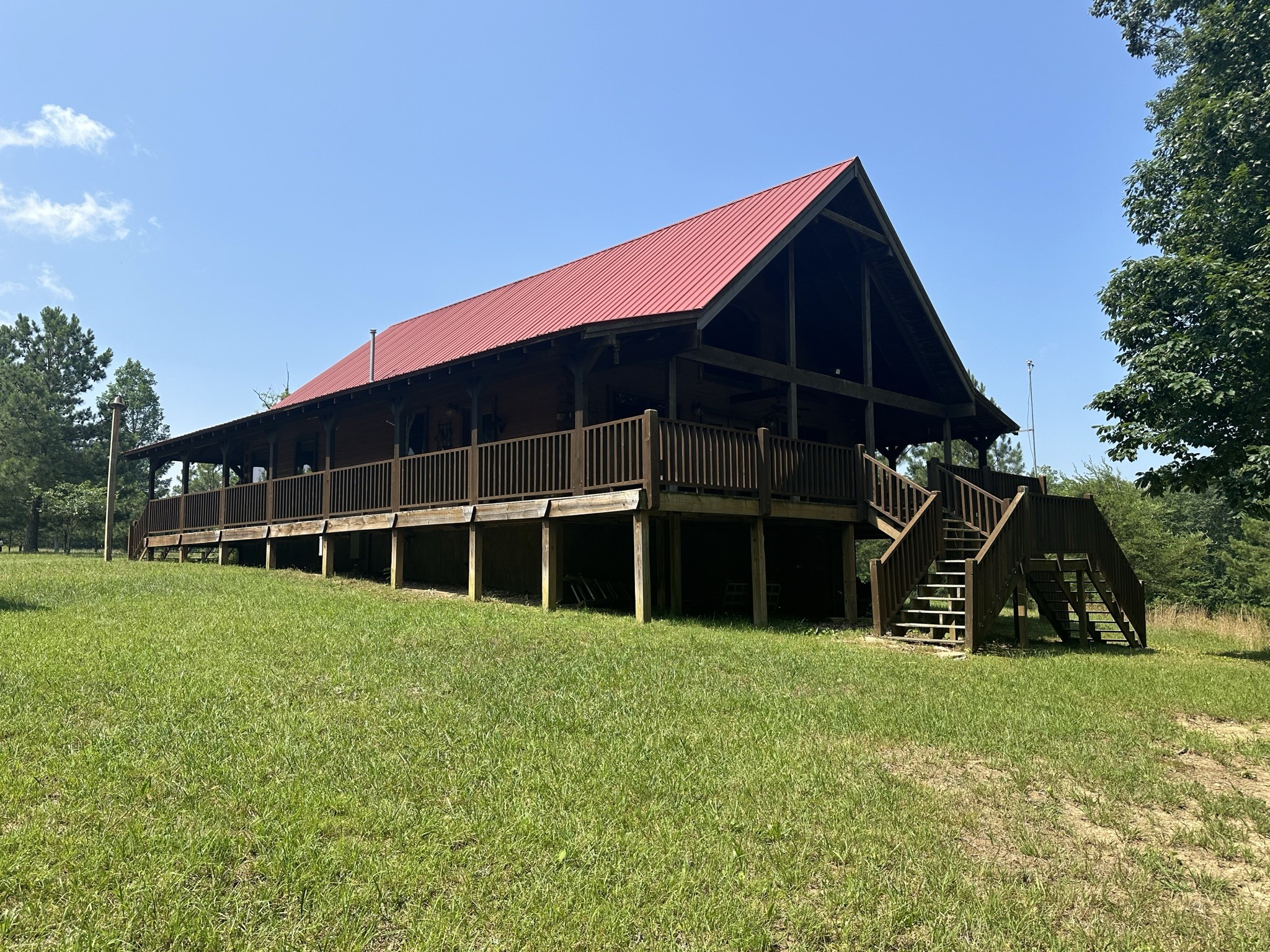 a view of a house with a big yard and large trees
