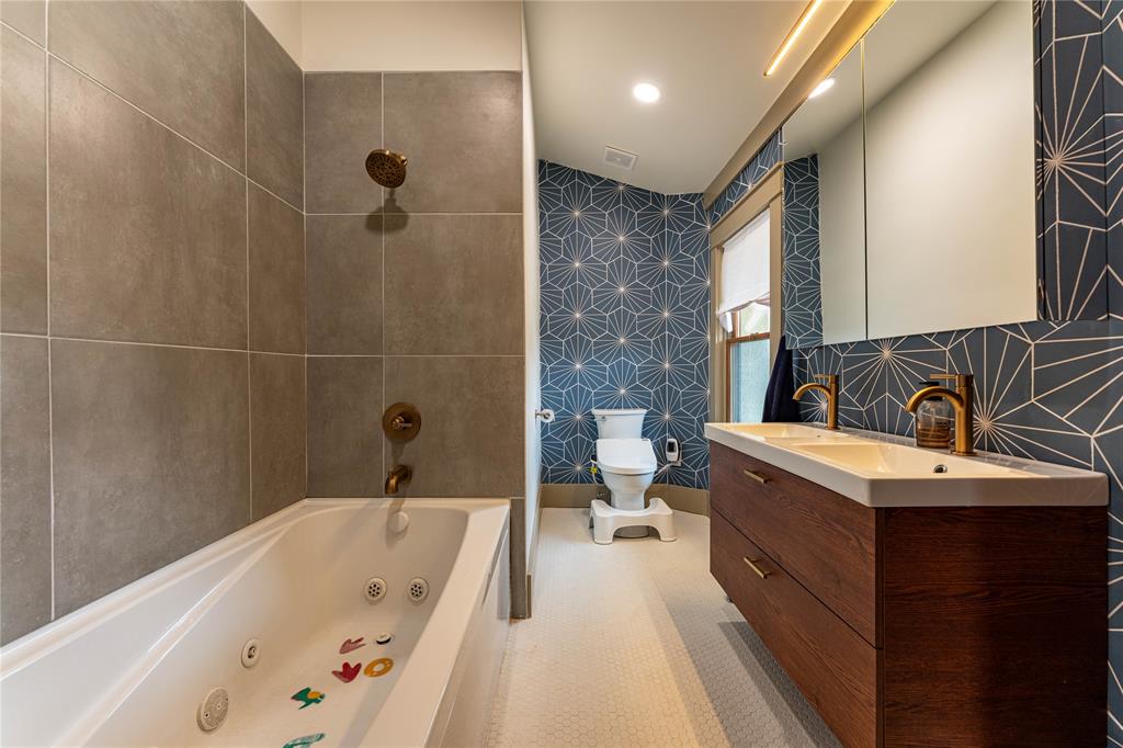 621 South Main Street Paris, TX 75460 - Photo 28 of 30 Full bathroom with double vanity, toilet, a combined bath / shower with jetted tub, and a sink
