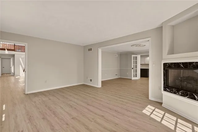 a view of a livingroom with wooden floor and a fireplace
