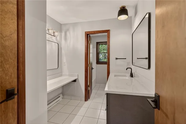 a en suite bathroom with a sink and mirror with toilet