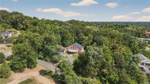 a aerial view of a house with a yard and large trees