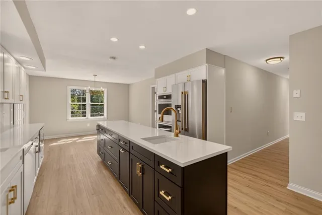 a kitchen with granite countertop a sink and a refrigerator