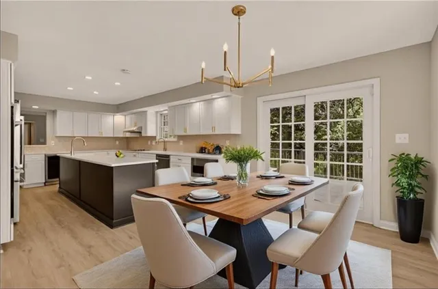 a open dining room with stainless steel appliances kitchen island granite countertop a dining table chairs and kitchen view