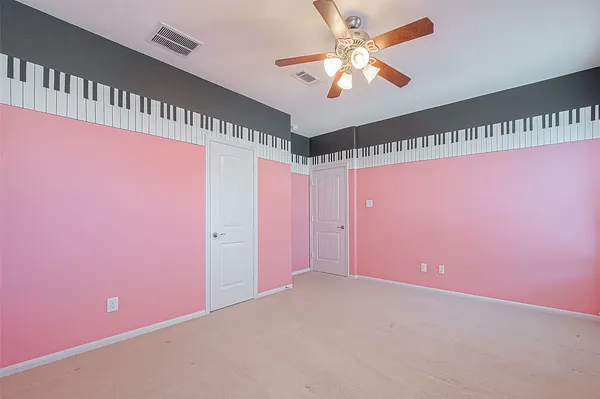 a view of an empty room with a chandelier fan and a window